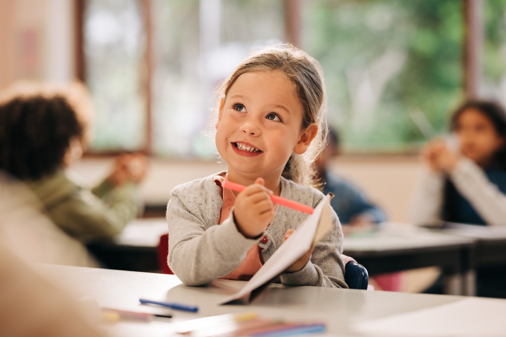 Young girl smiling and learning in school