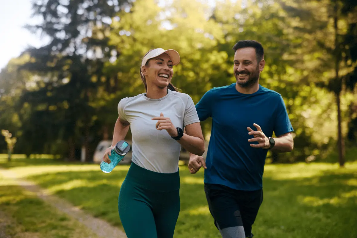 two adults running outdoors and smiling